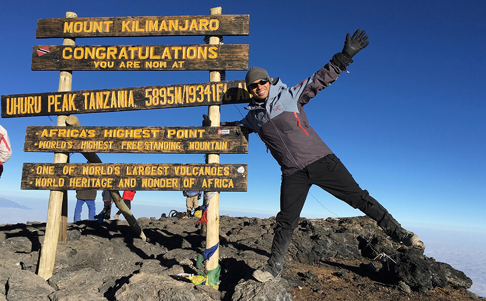 Dr. Michael Mison at the summit of Kilimanjaro in Tanzania, the highest mountain in Africa.