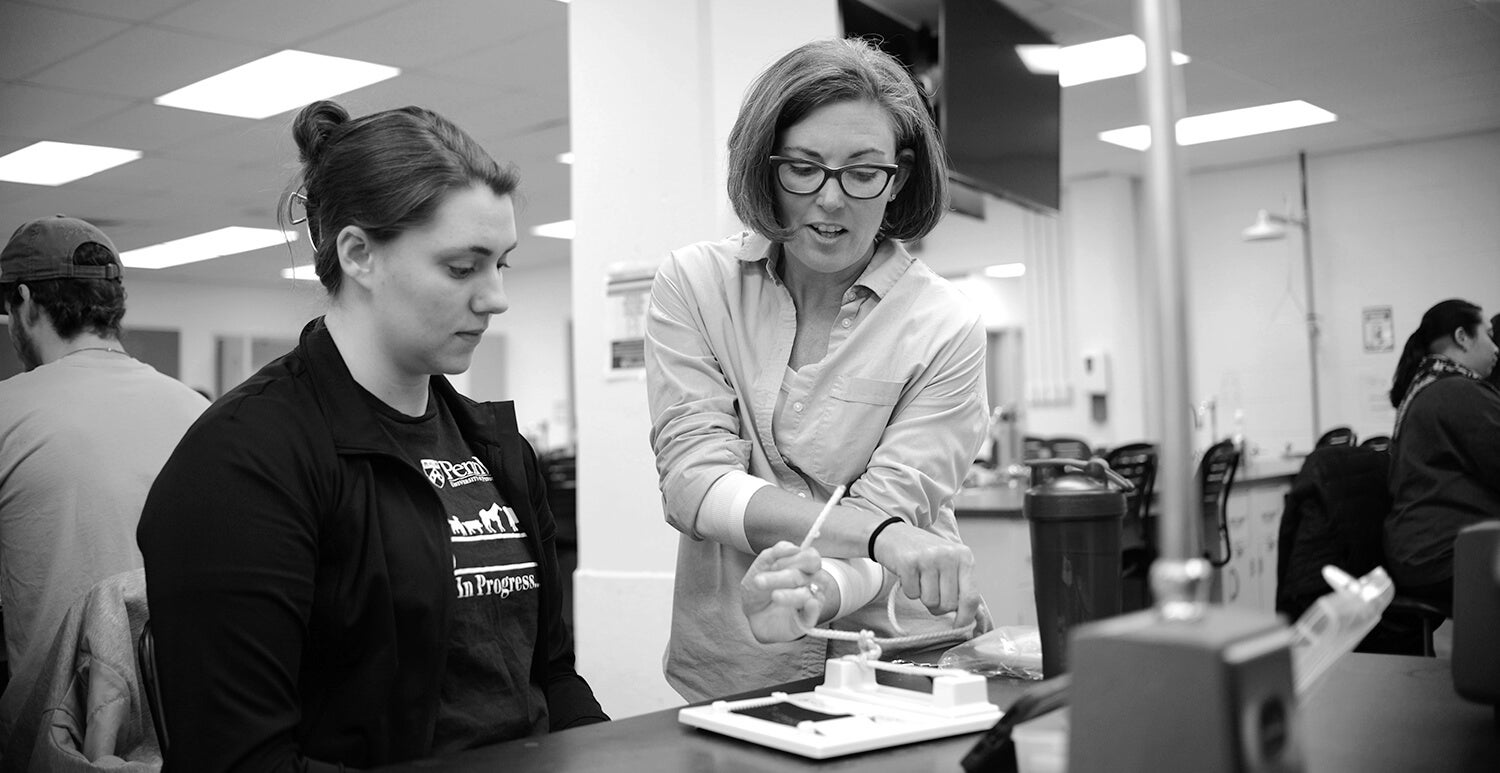 Dr. Jennifer Huck (right) teaches a first-year student how to perform a surgical hand tie. Photo of Dr. Jennifer Huck teaching a student