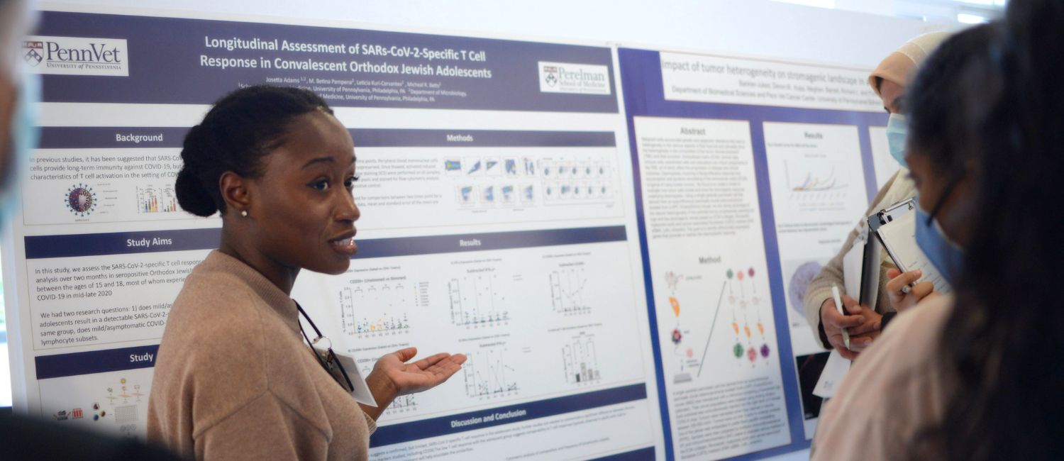 A student presenting in front of a poster.