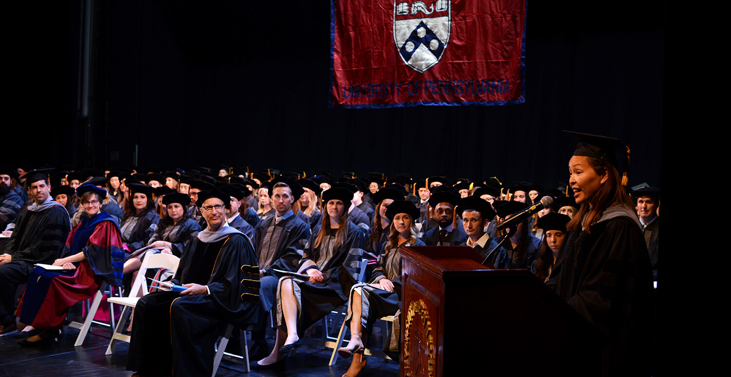 Photo of speaker addressing gathered graduates