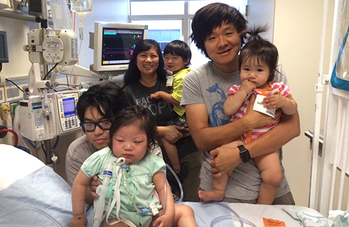 Brian Chan, right, and family visit with Galya (in green) in the intensive care unit.
