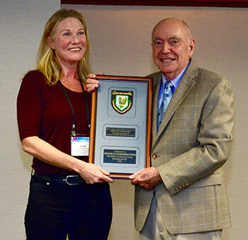 Dr. Julie Engiles presents the award to Dr. Michael Goldschmidt
