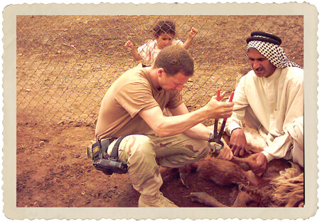 CPT Eric Lombardini trimming a goat's hooves in Southern Iraq, OIF, 2004.