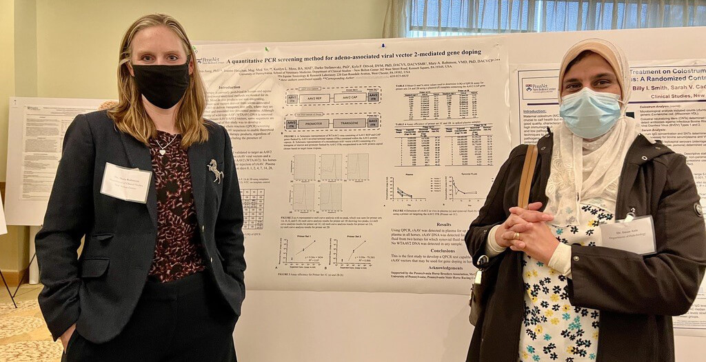 Drs. Mary Robinson and Eman Anis (right) stand in front of Dr. Robinson's poster presentation.