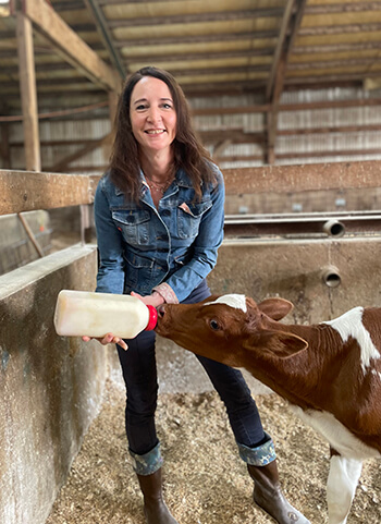 Dr. Amber Itle feeding a calf