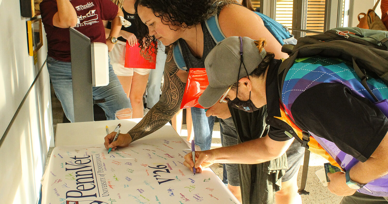 Students sign the Class banner that will hang in the student lounge.