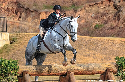 Photo of Dr. Modesty Burleson on a horse jumping