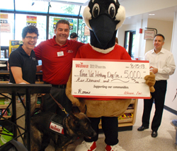 Wawa Store Operations Director Terrance Herling and mascot Wally Goose present Dr. Cindy Otto with a check for the sponsorship of Ronnie.