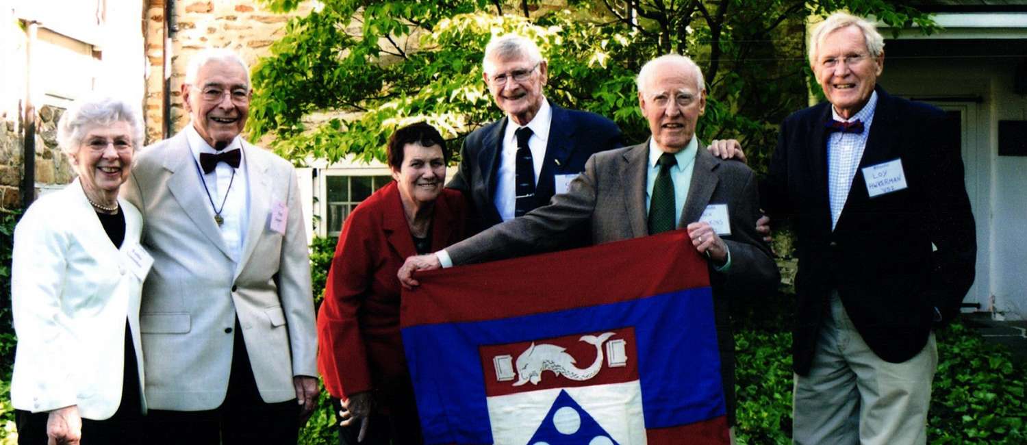 Jack Langley Wilkins  V’52 with other alumns, holding a flag