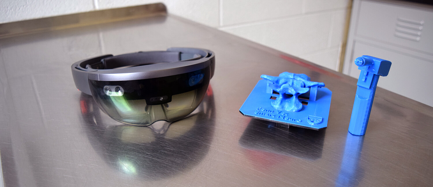 The Microsoft HoloLens, the 3D printed spinal cord model, and 3D printed version of the drill used in surgery. 