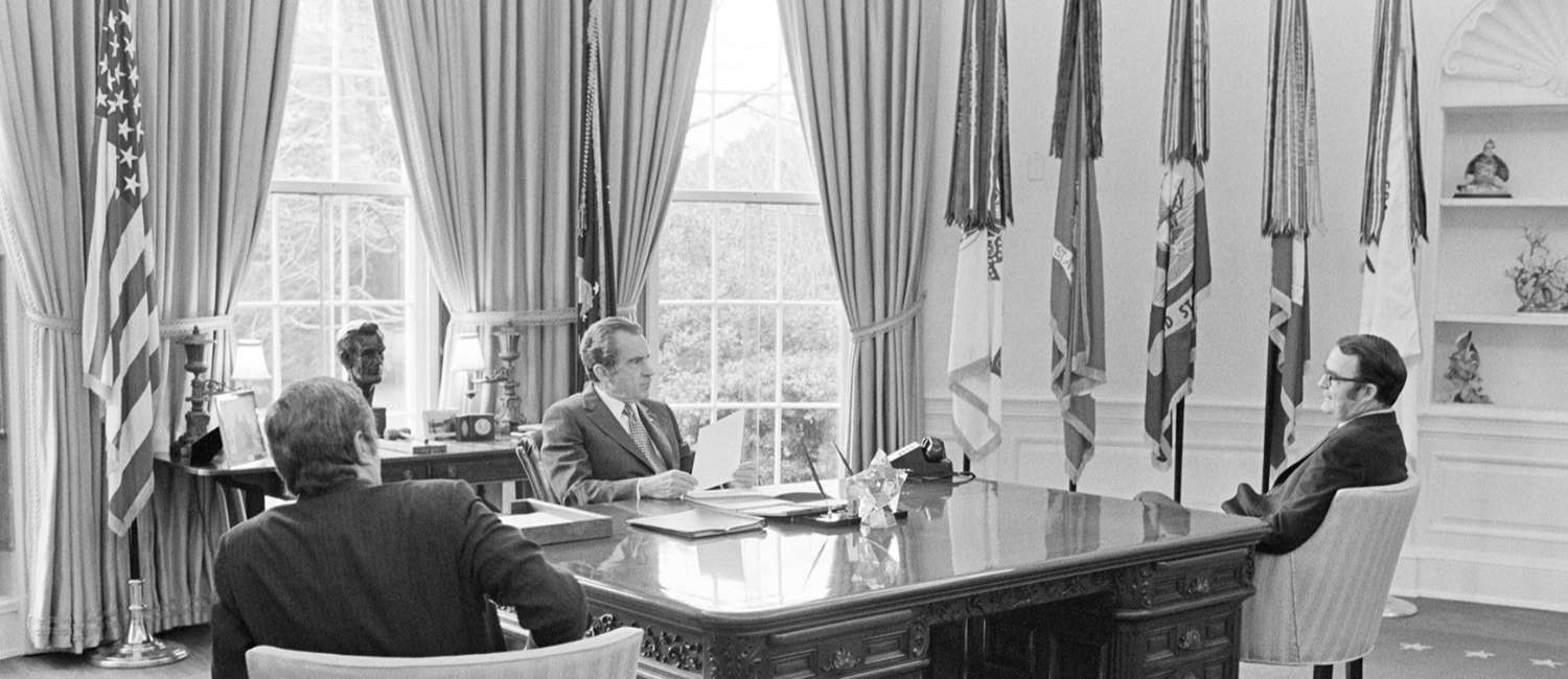 Richard Nixon sitting at desk in Oval Office