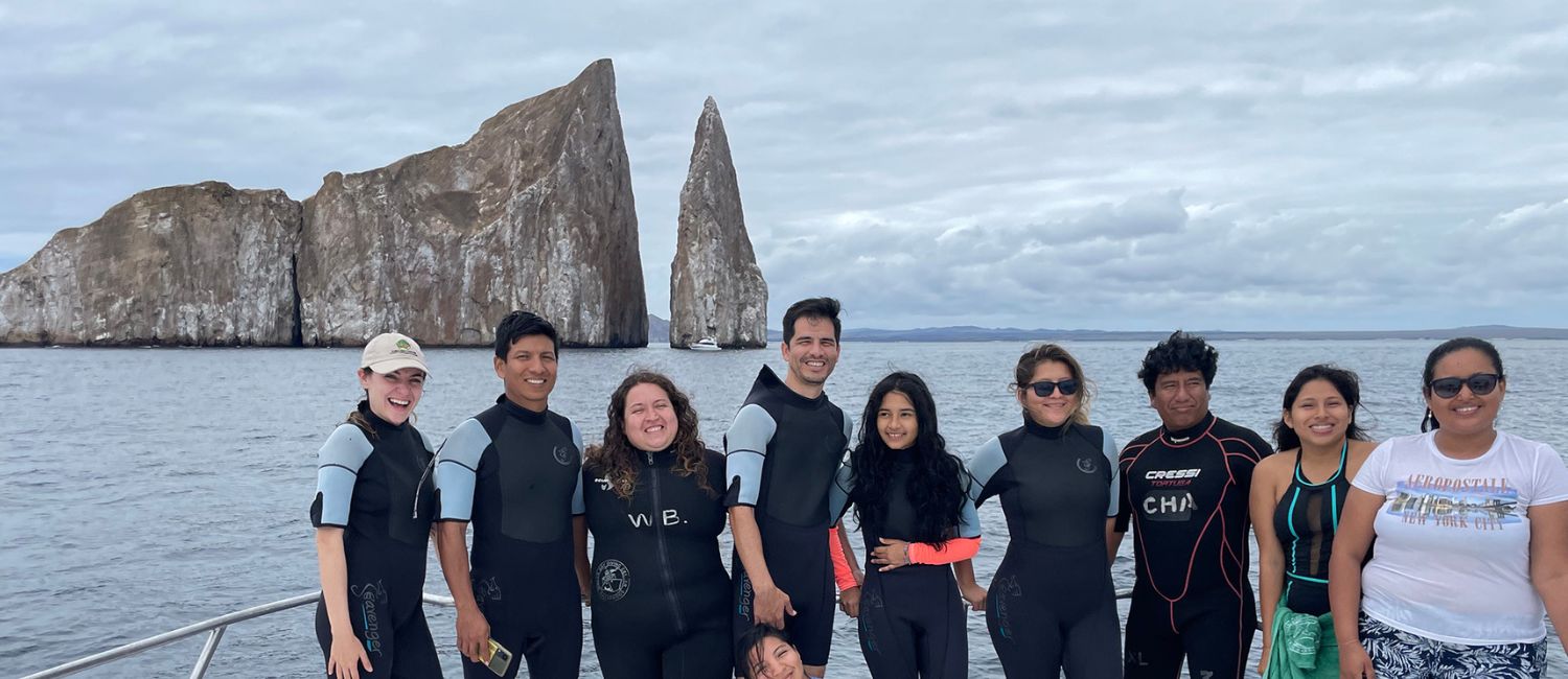 galapagos students standing on the edge of a boat