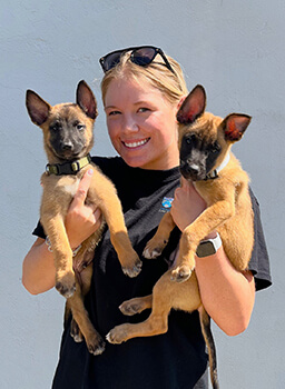 Working Dog Center Foster Program Coordinator Sarah Gally with Loki and Redd