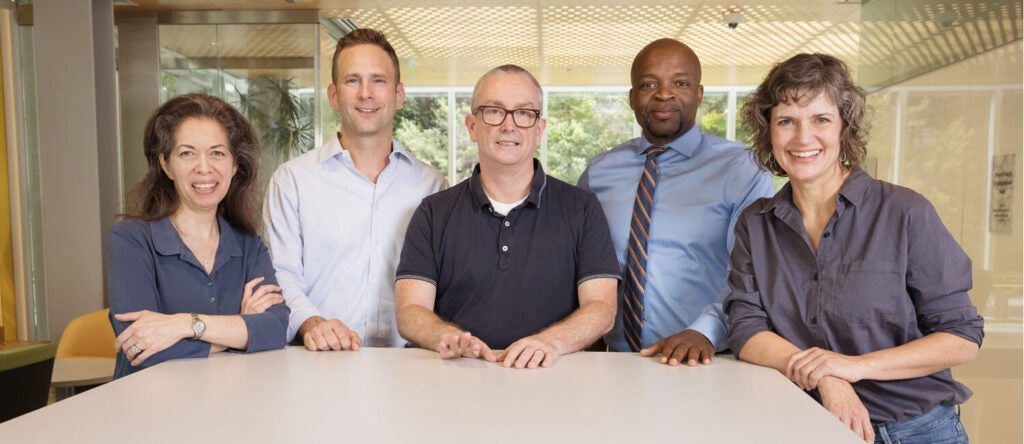 Five people looking at the camera in business casual clothes.