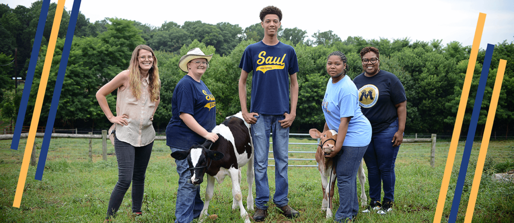 People standing in a field with students.