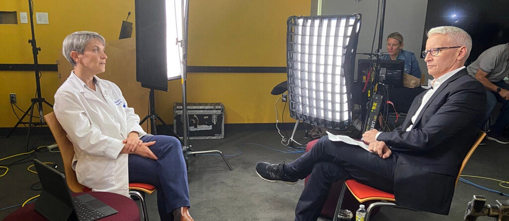 A doctor being interviewed in front of a tv crew.