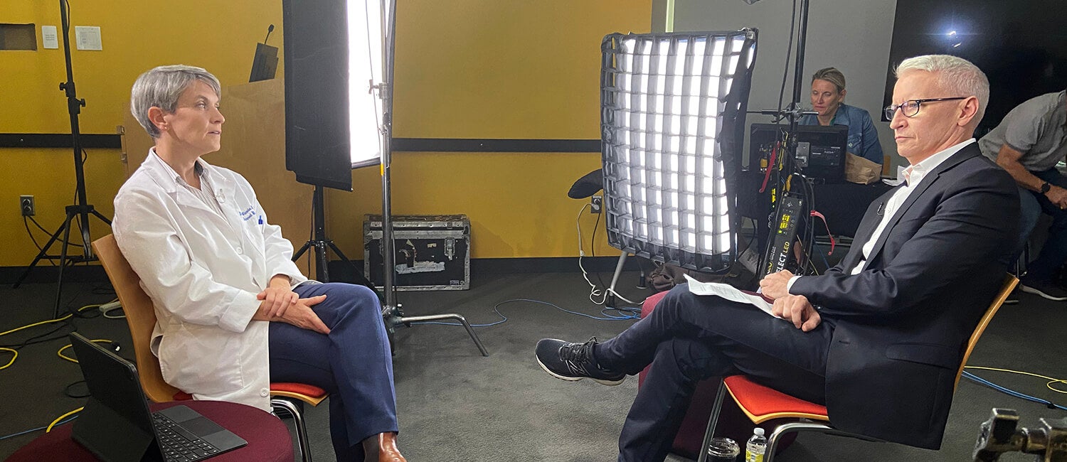 A doctor being interviewed in front of a tv crew.
