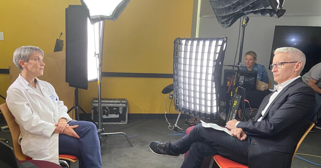 Two people sitting across from each other during a tv interview.