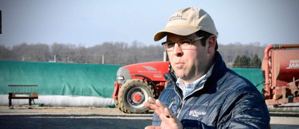 A man standing outside in front of a large tractor.