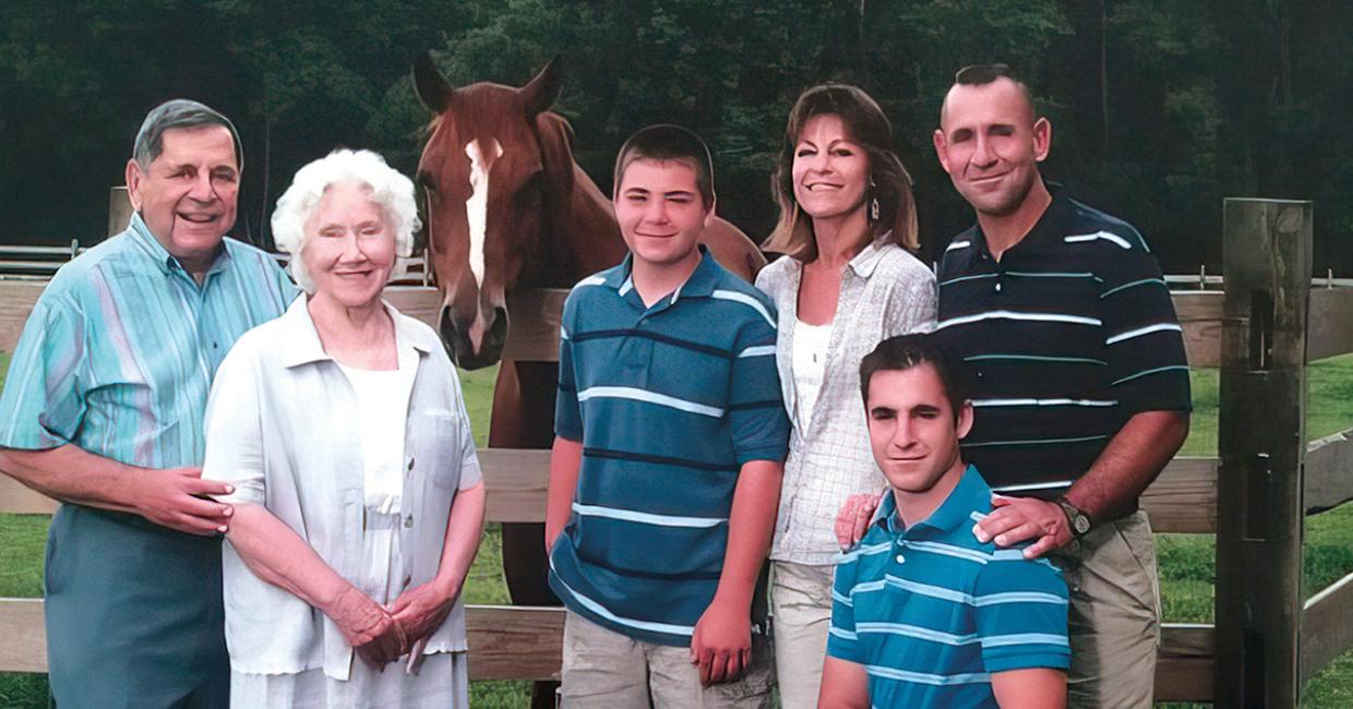 A group of people standing in front of a horse.