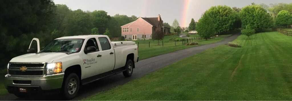 A white truck parked next to a green field.