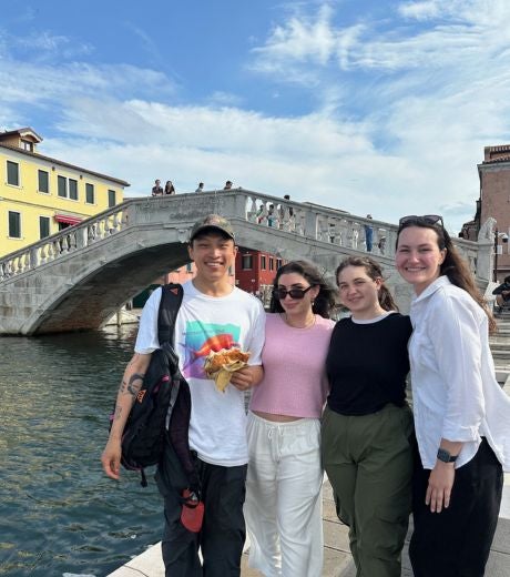 Four students in front of a bridge