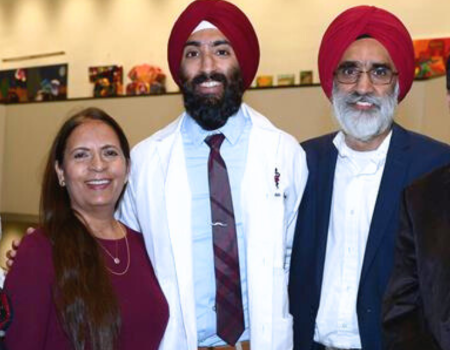 a family poses for a photo with a person in a turban