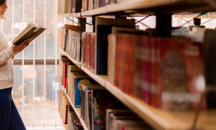 A person is reading a book in a library