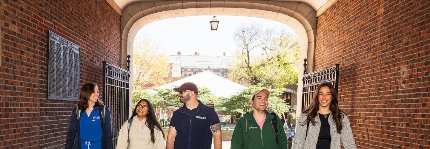 a group of students walking through an archway