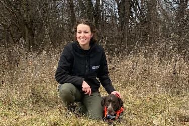 Woman and working dog in field