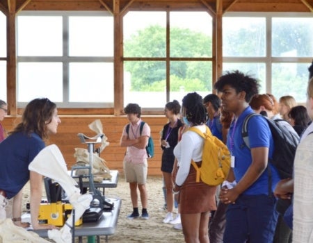 a group of people standing around a table in a barn