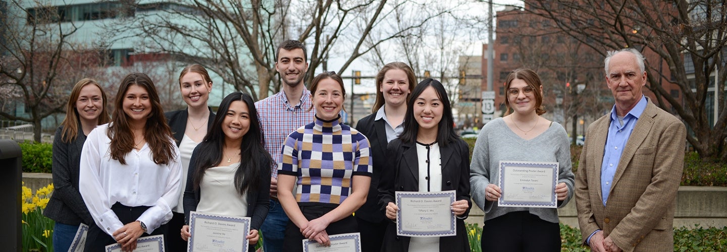 a group of people holding certificates in front of a building