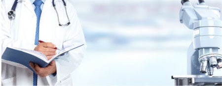 A person standing next to a piece of lab equipment.