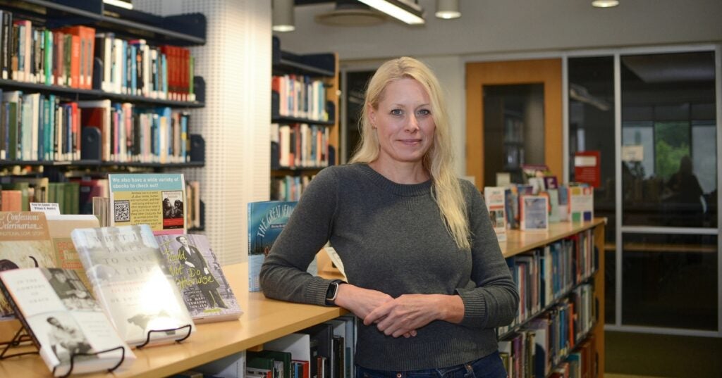 A person standing in front of bookshelves in a library