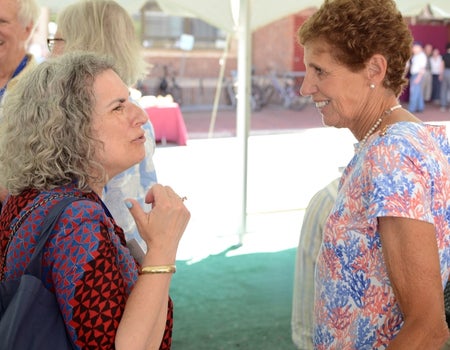 Two people standing and talking with each other.