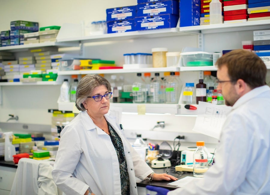 Two people in lab coats talking to each other.
