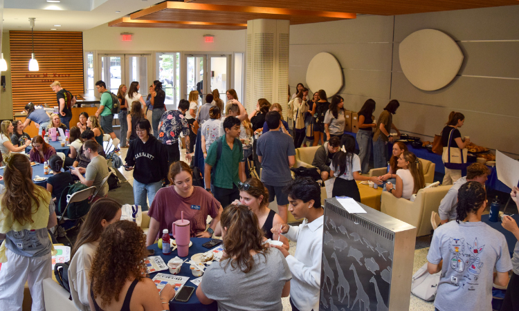 New students gather in the Hill building lobby and mingle over breakfast bagels.