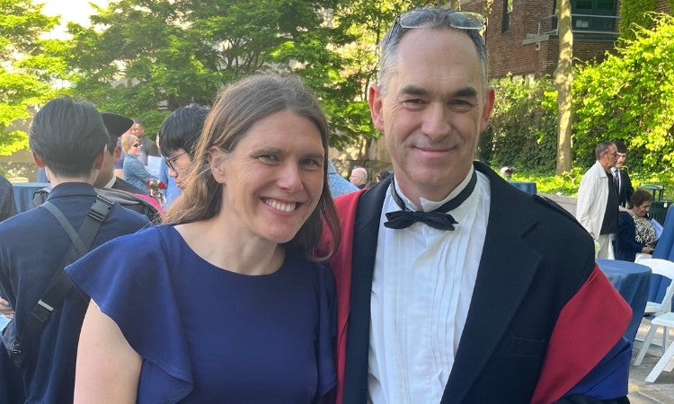 Two people posing for a photo at a graduation ceremony