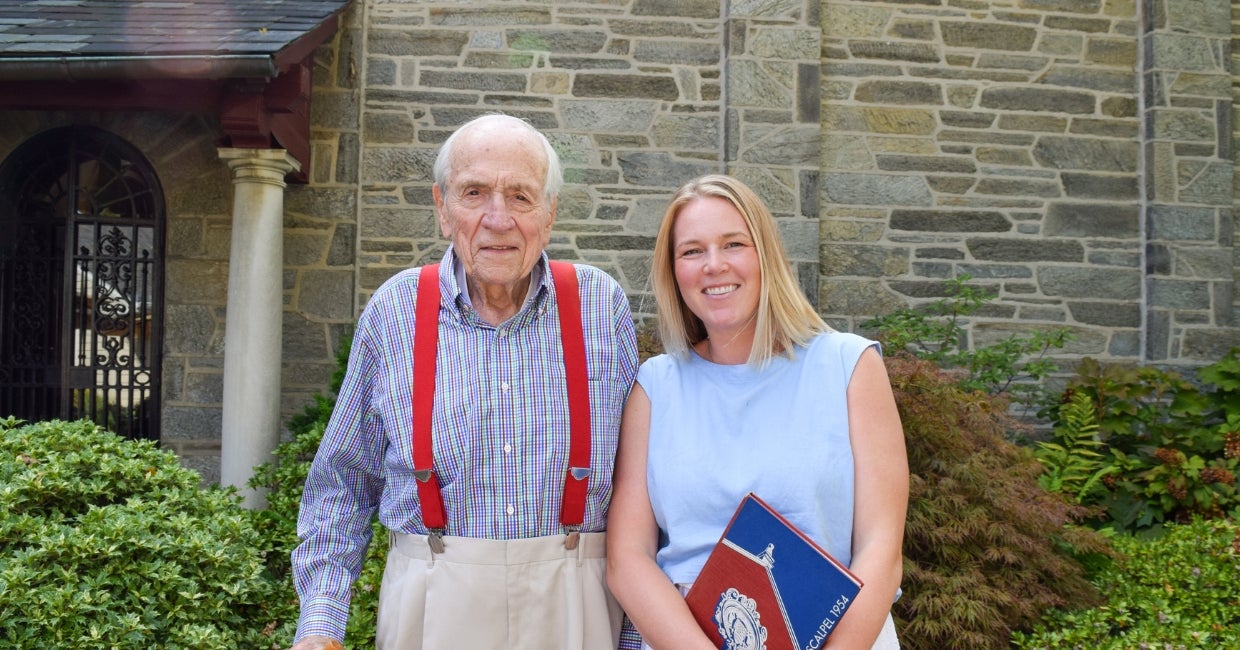A man and woman standing in front of a stone building