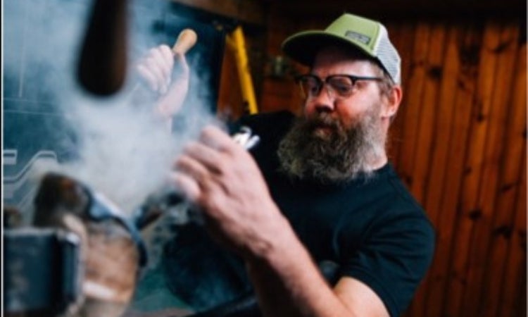 A person working on a horse shoe.