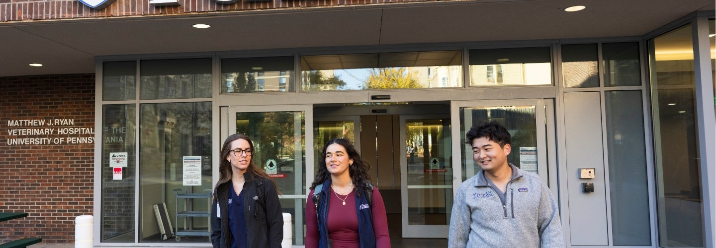 Three people standing in front of the Penn Vet Ryan Hospital building.