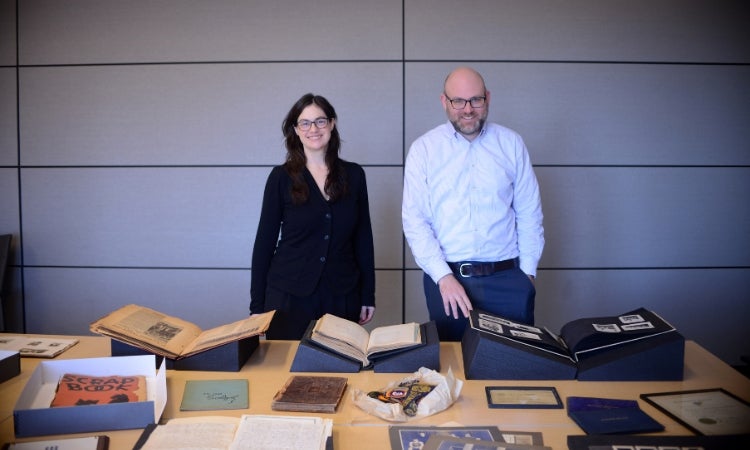 Two people standing in front of a table with pictures on it.