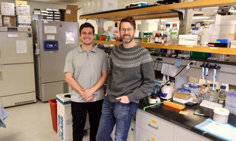 two people standing next to each other in a laboratory