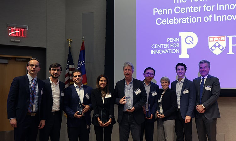 A group of people standing in front of a screen.