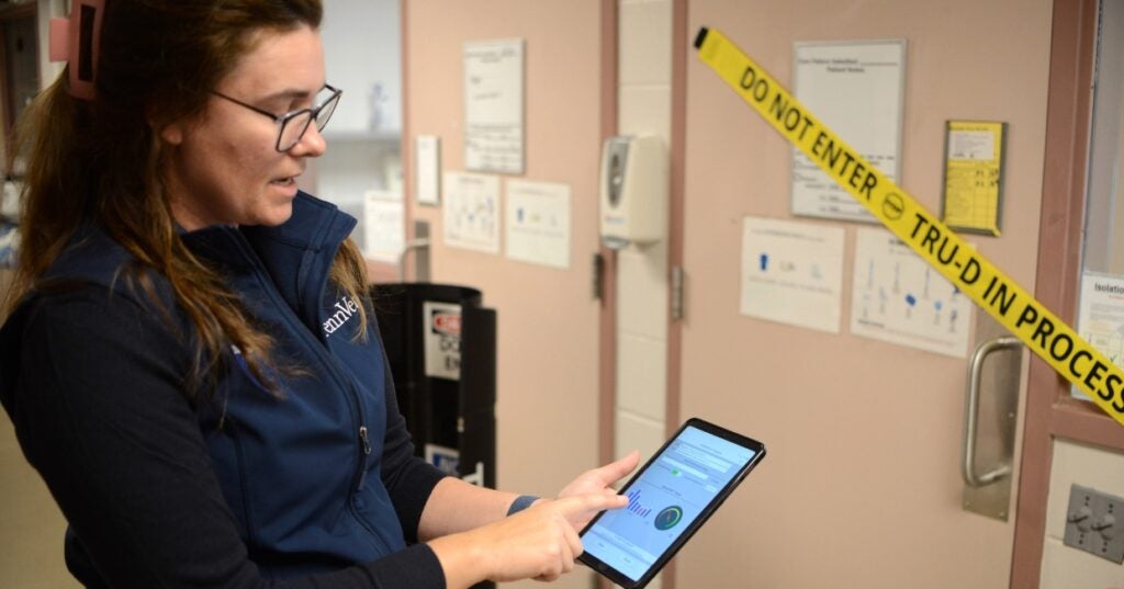a person standing in front of a door holding a tablet